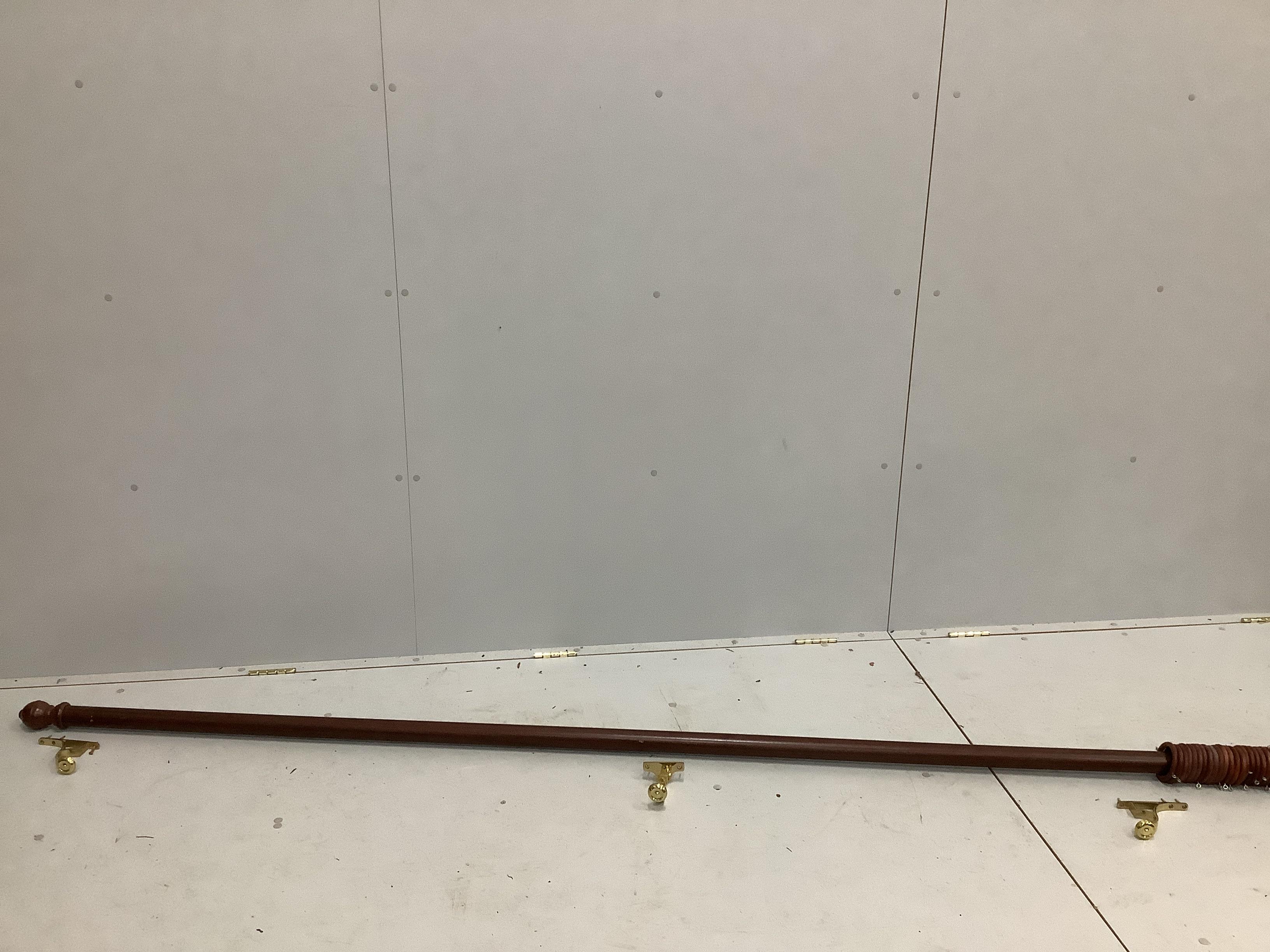 A Victorian style wooden curtain pole with twenty four wooden rings and brass fixing brackets, width 270cm